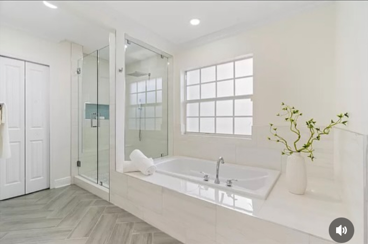 Bathroom renovation with glass shower, soaking tub, and herringbone flooring in West Palm Beach